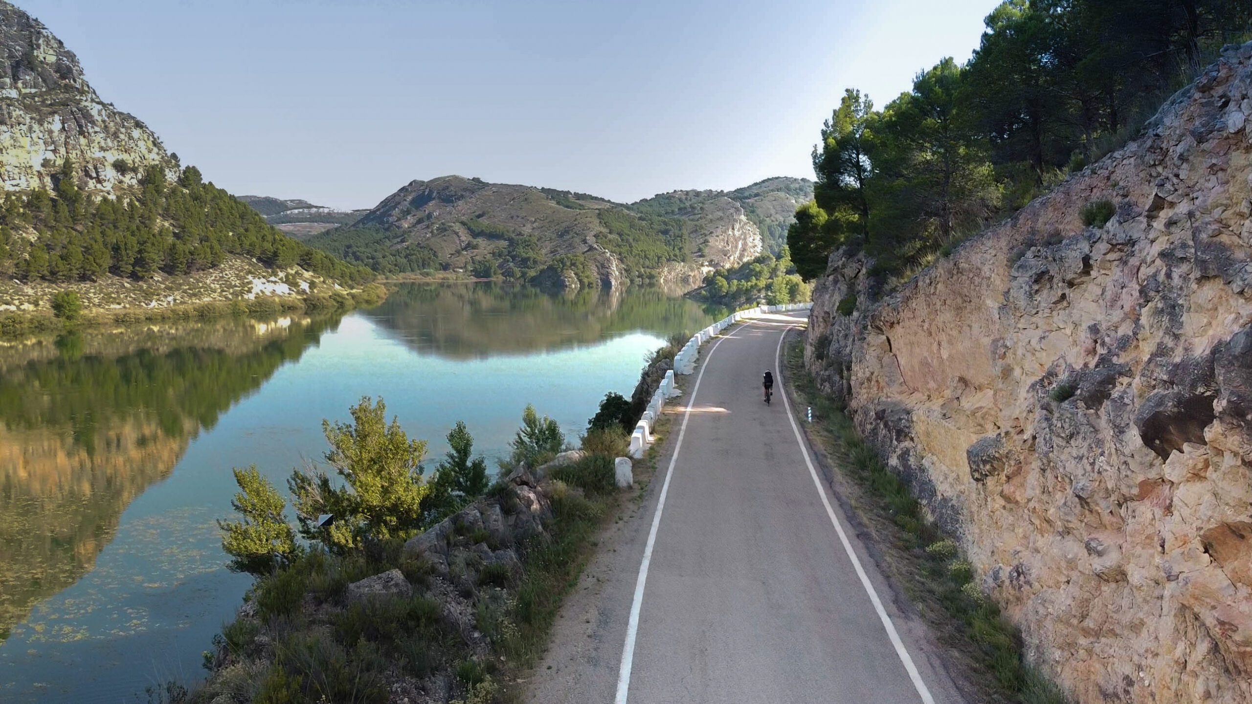 Imagen del pantano de nuevalos con ciclista en carretera perimetral